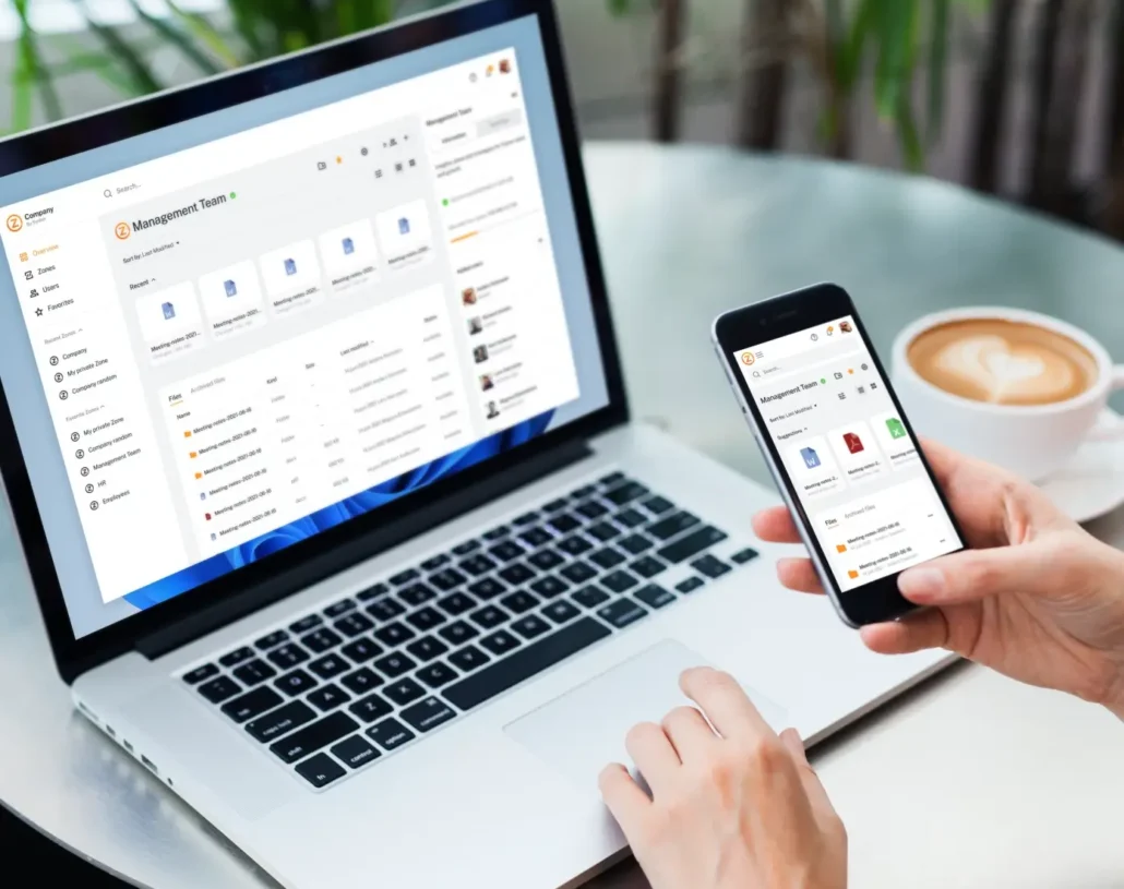 laptop och person som håller i telefon synkzone